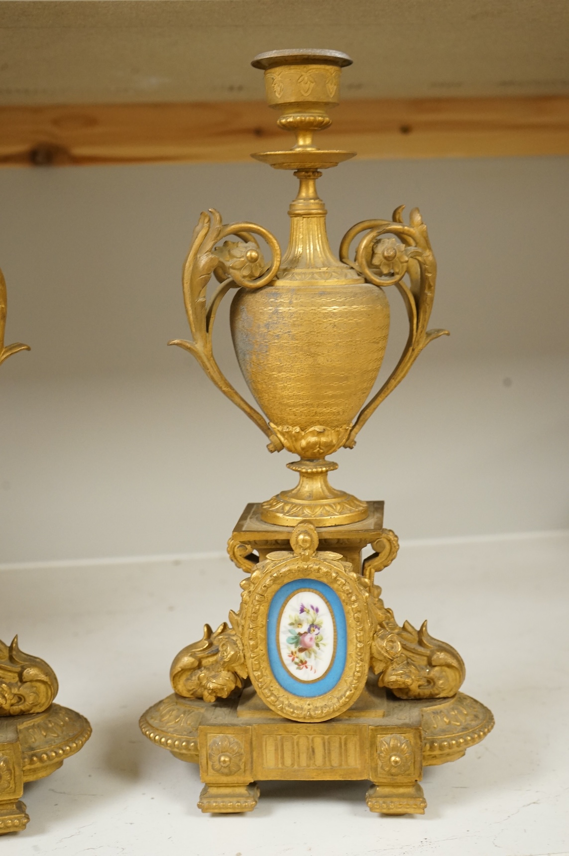 A pair of 19th century gilt metal candlesticks with inset porcelain panels, 32cm high